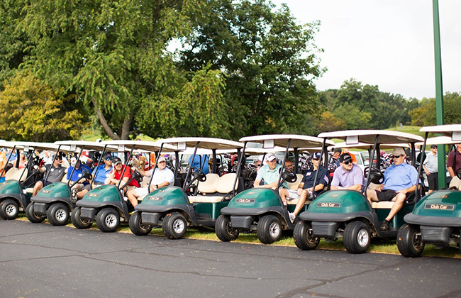 Rows of golfers in golf carts